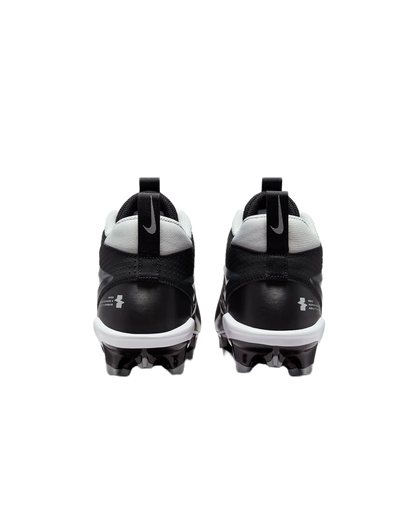 Rear view of black and white Nike Alpha Menace Varsity 4 cleats with cleated soles for football.