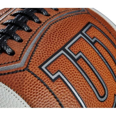 Nærbilde av Wilson GST Prime Football som viser teksturert grep, svarte lisser og detaljert søm på brun, nubret overflate.