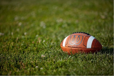 Wilson GST Prime Football med forbedret grep og høy synlighet-detaljer på gressbane.